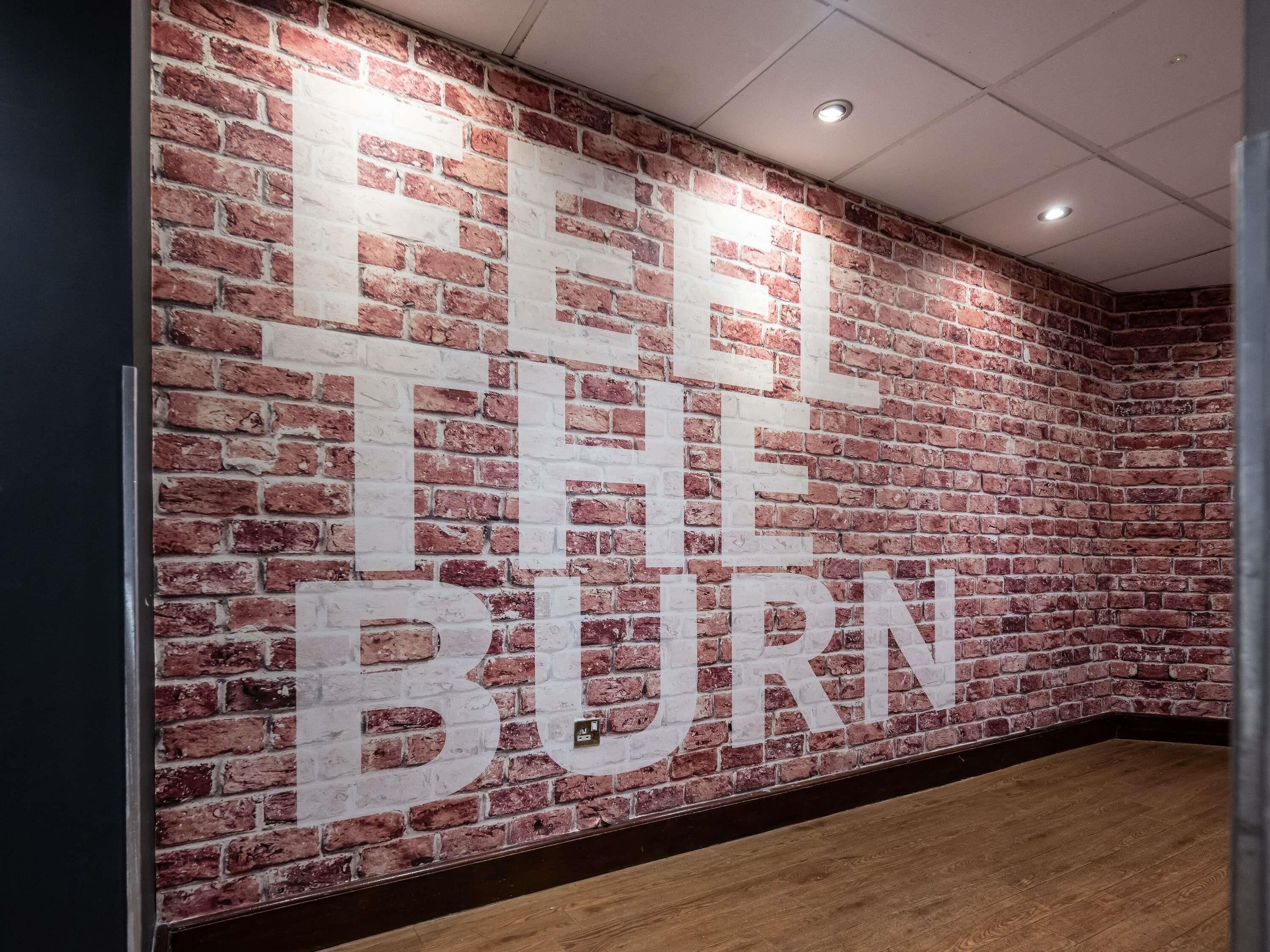 A brick wall with the text 'FEEL THE BURN' in large letters.