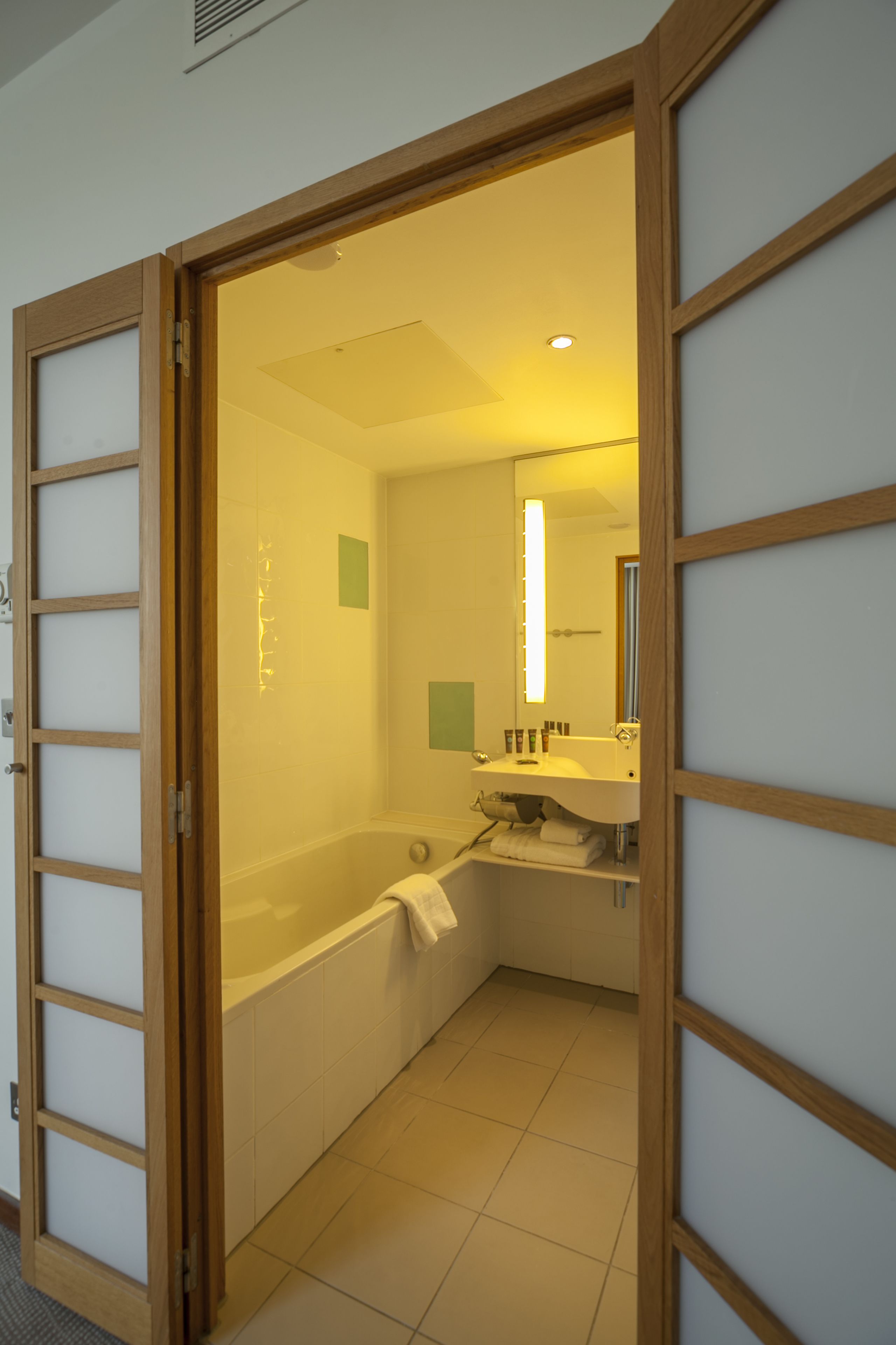 A bathroom with a bathtub, a sink, and a mirror.