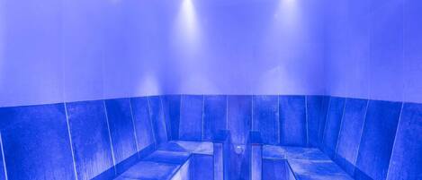 A blue-tiled room with a central column and two overhead lights.