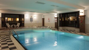 A swimming pool with a checkered floor, lounge chairs, and a brick pillar. - Holiday Inn Birmingham Bromsgrove by IHG (Bromsgrove)