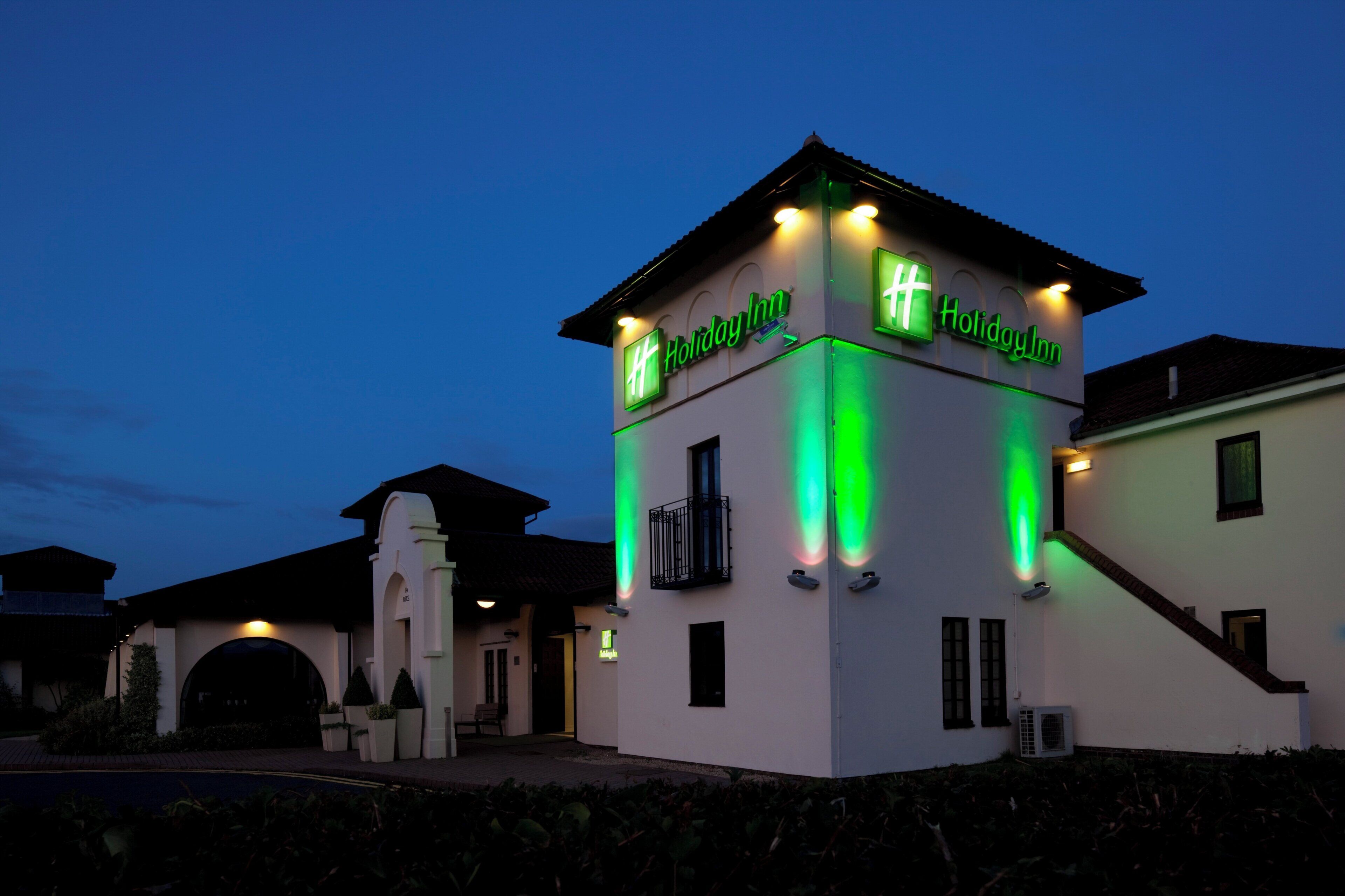 Un hotel Holiday Inn con una torre destacada y señalización iluminada.