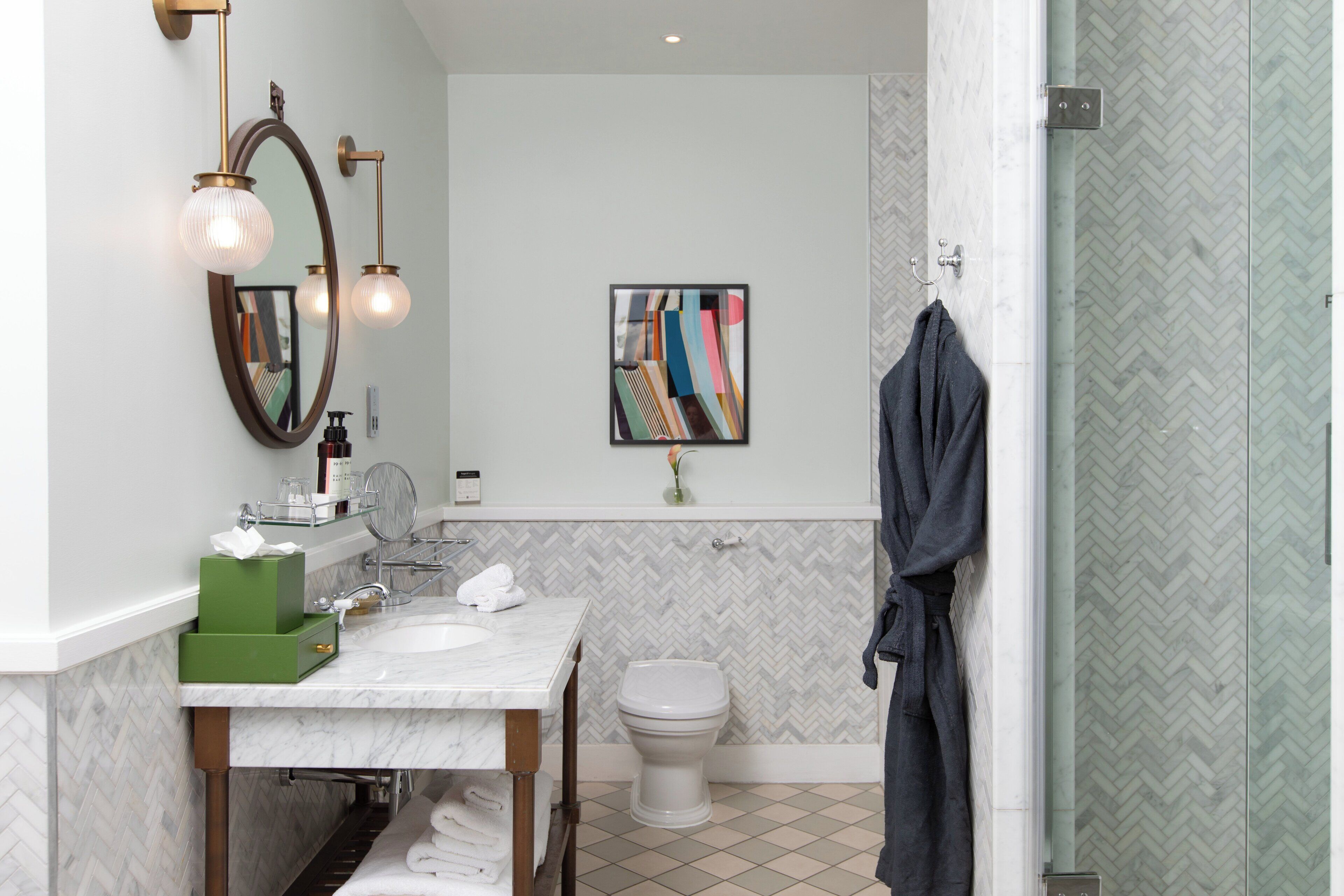 Une salle de bain moderne avec un lavabo en marbre, deux miroirs, des toilettes et un espace douche.