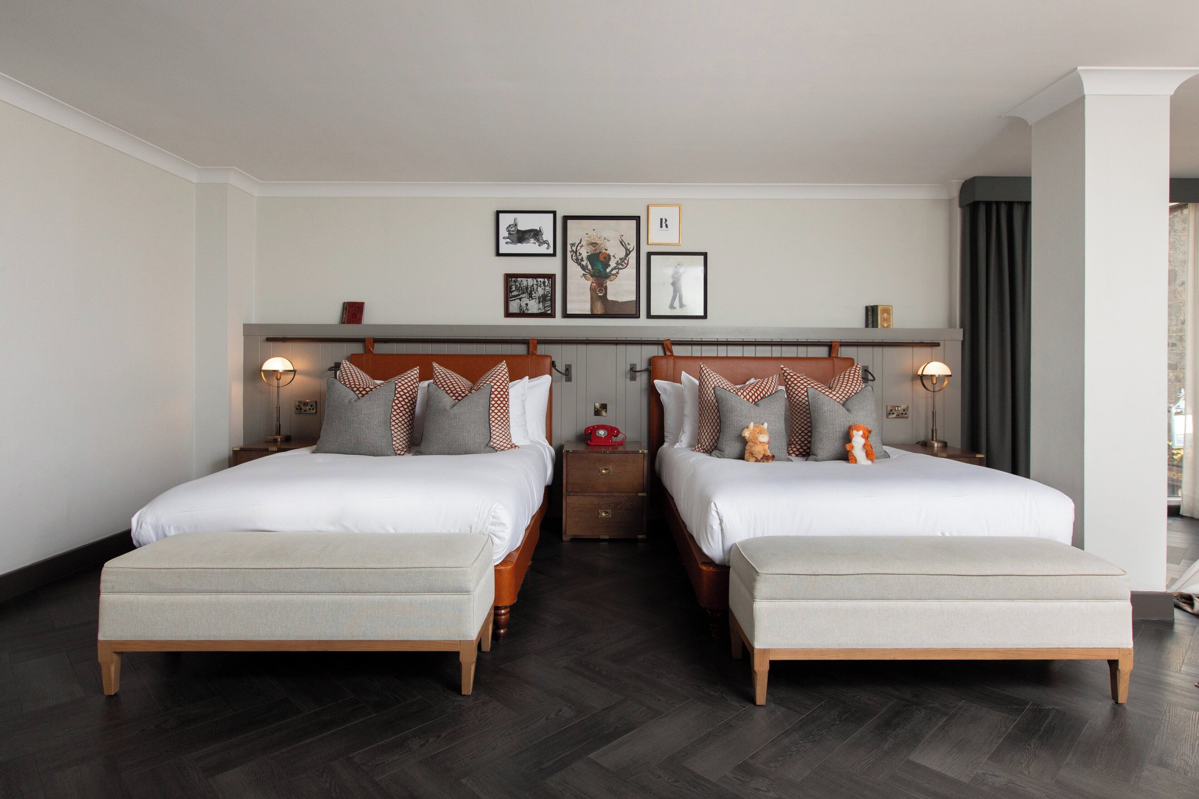 A double room with two beds, a nightstand, and a wall-mounted shelf with framed pictures.