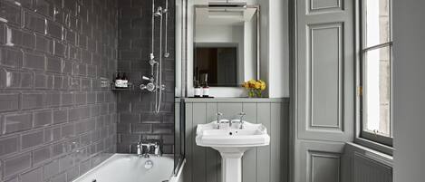 Ein modernes Badezimmer mit Badewanne, Waschbecken und einem großen Spiegel.