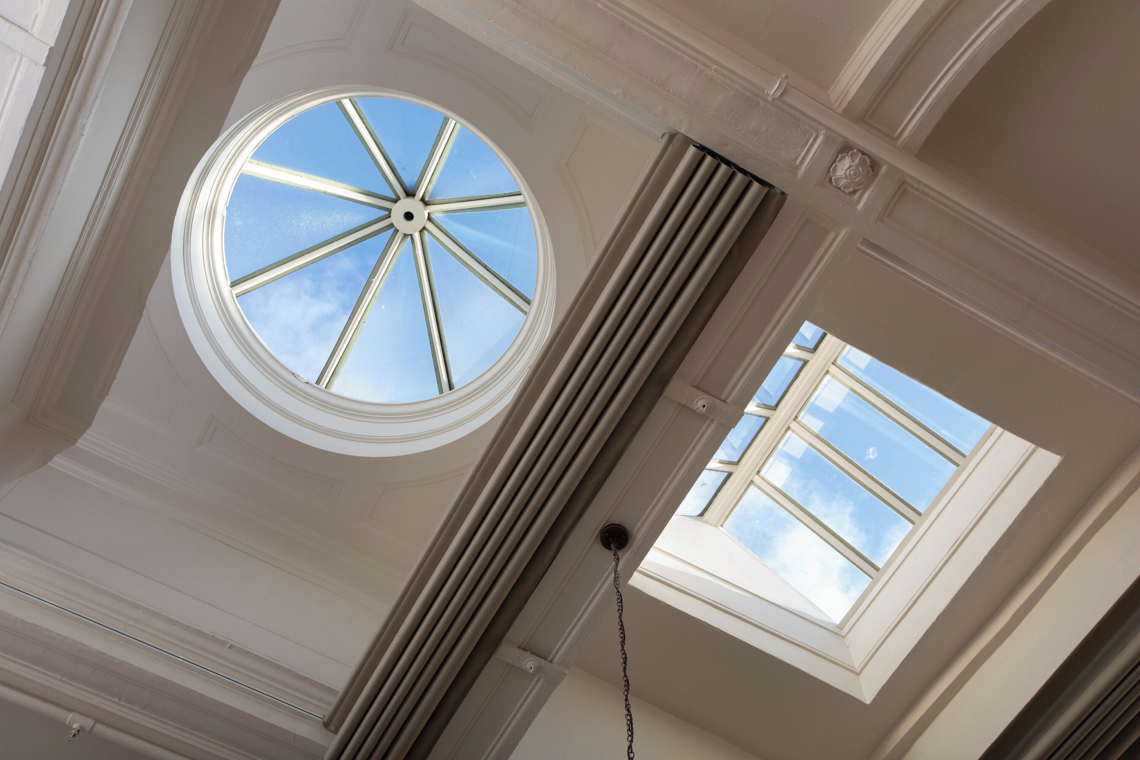 A room with a skylight and a window, both allowing natural light to enter.