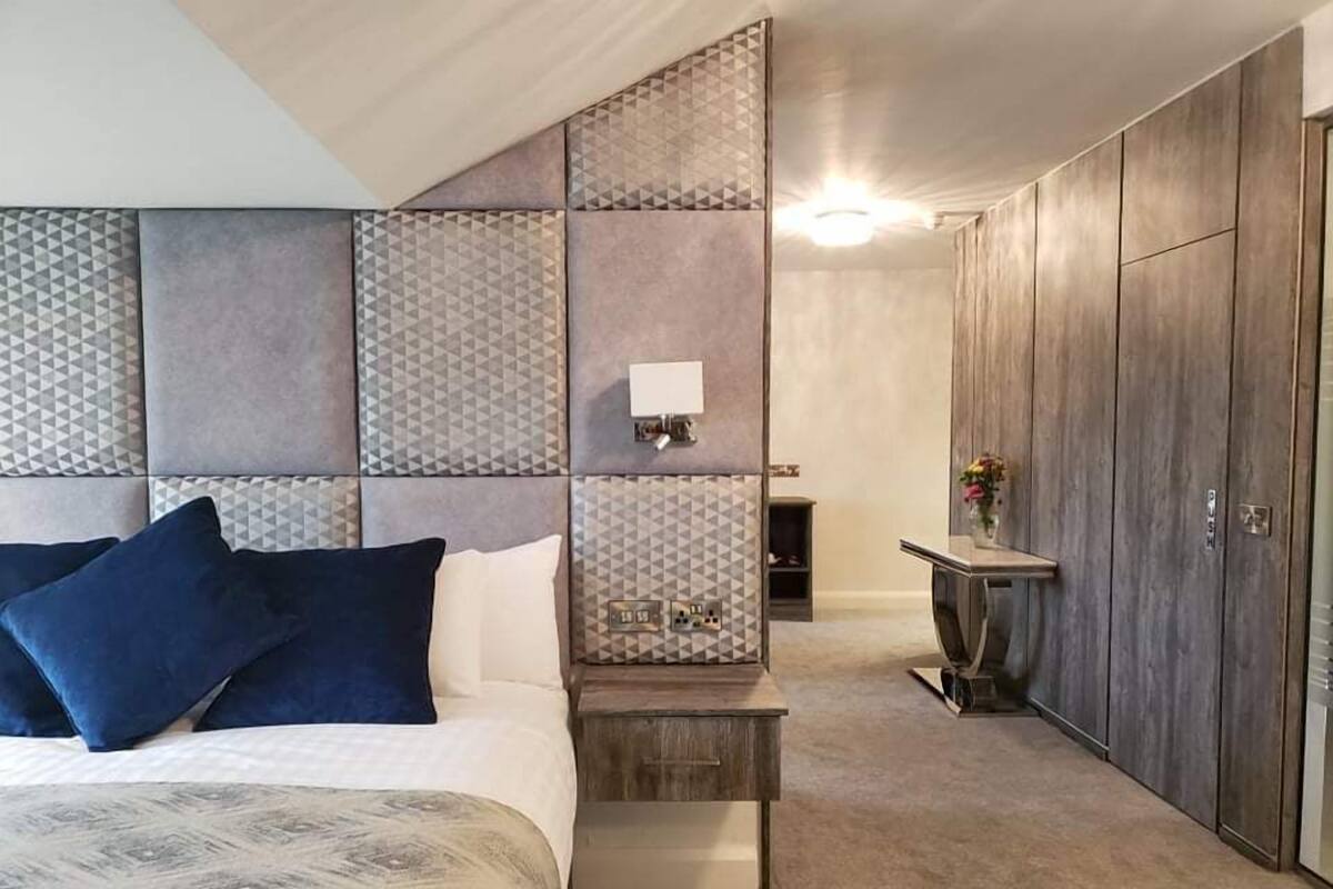 A bedroom with a bed, bedside table, and a wardrobe.