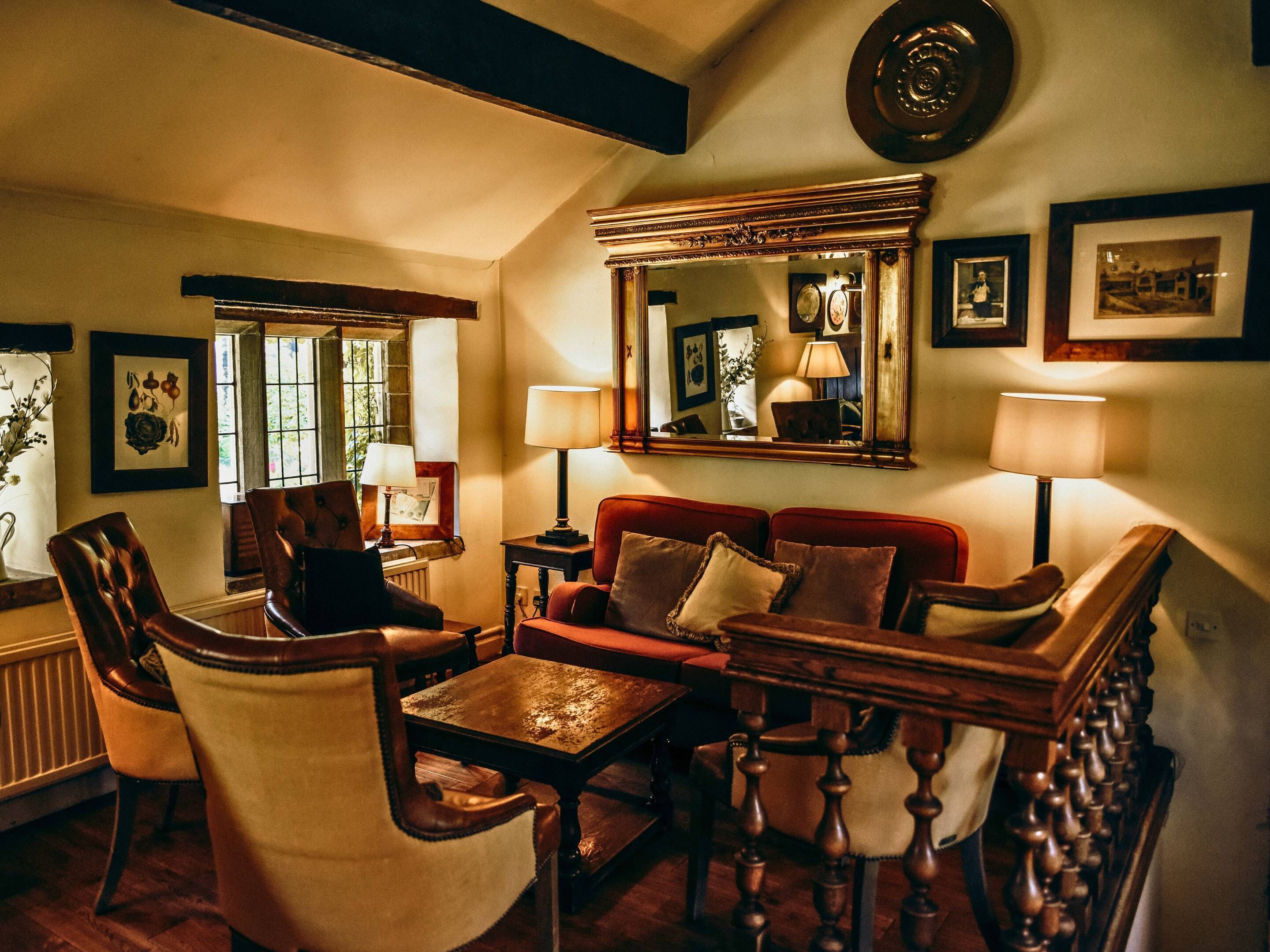 A cozy living room with a fireplace, comfortable seating, and a large mirror.