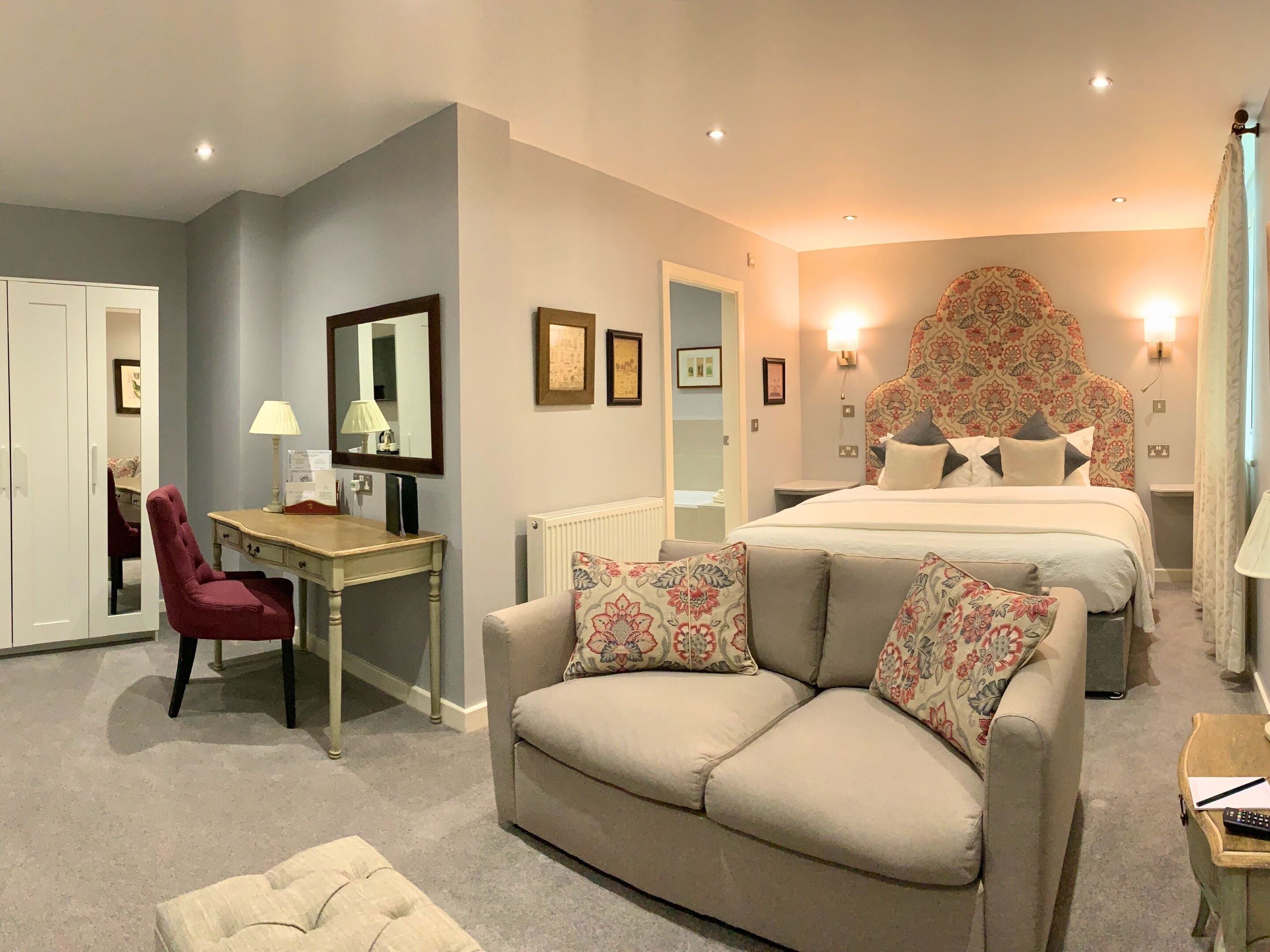 Une chambre à coucher avec un lit, un canapé, un bureau et une chaise.