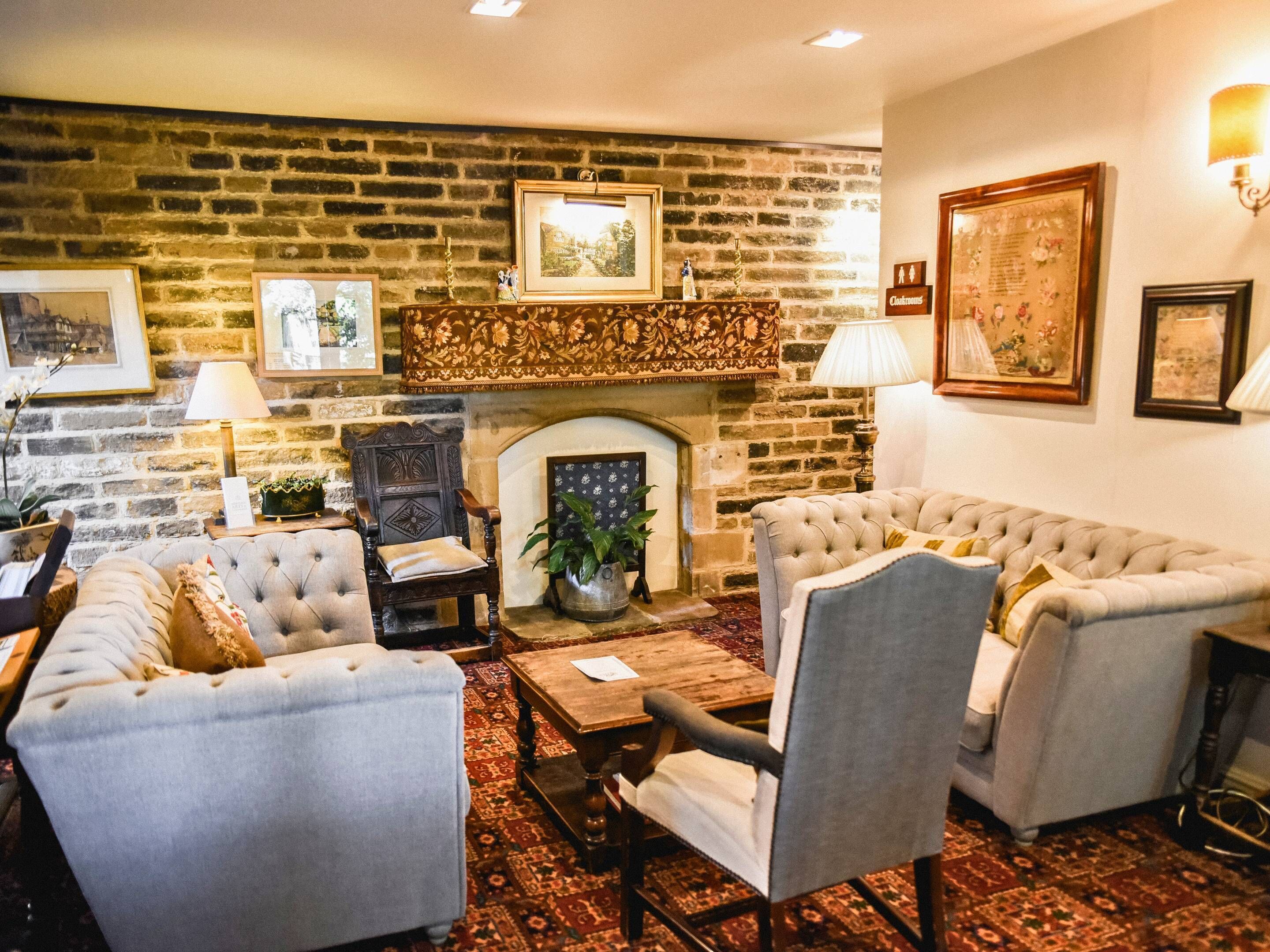 Una sala de estar acogedora con chimenea de ladrillo, asientos confortables y decoración en las paredes.