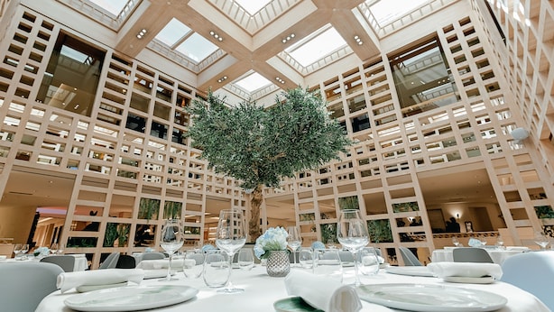 A spacious dining area with high ceilings and natural light, featuring a central tree and modern table settings. - Hyatt Regency Hesperia Madrid (Madrid)