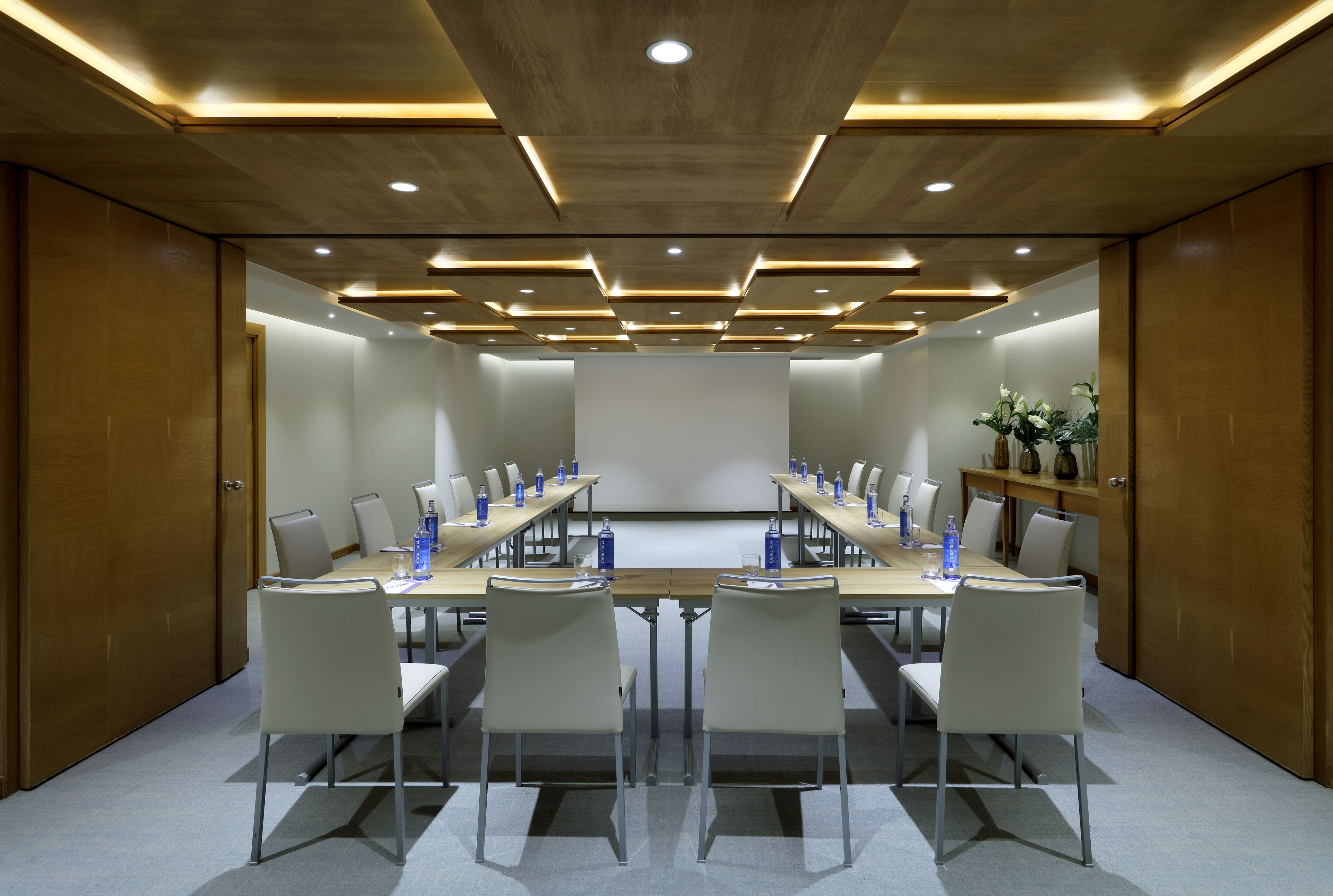 A conference room with a long table, chairs, and a whiteboard.
