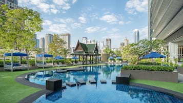 Una piscina al aire libre, camas de piscina gratis, sombrillas