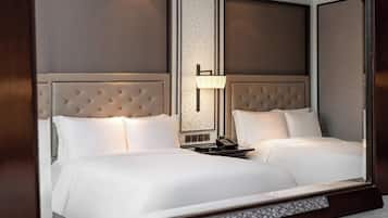 A hotel room with a large bed, a bedside table with a lamp, and a mirror.
