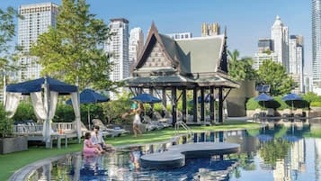 Una piscina al aire libre, camas de piscina gratis, sombrillas