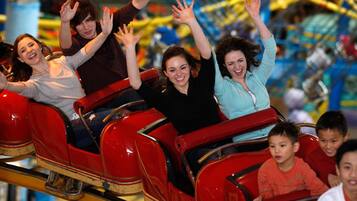 A group of people on a red amusement ride with a metal frame and yellow support beams.