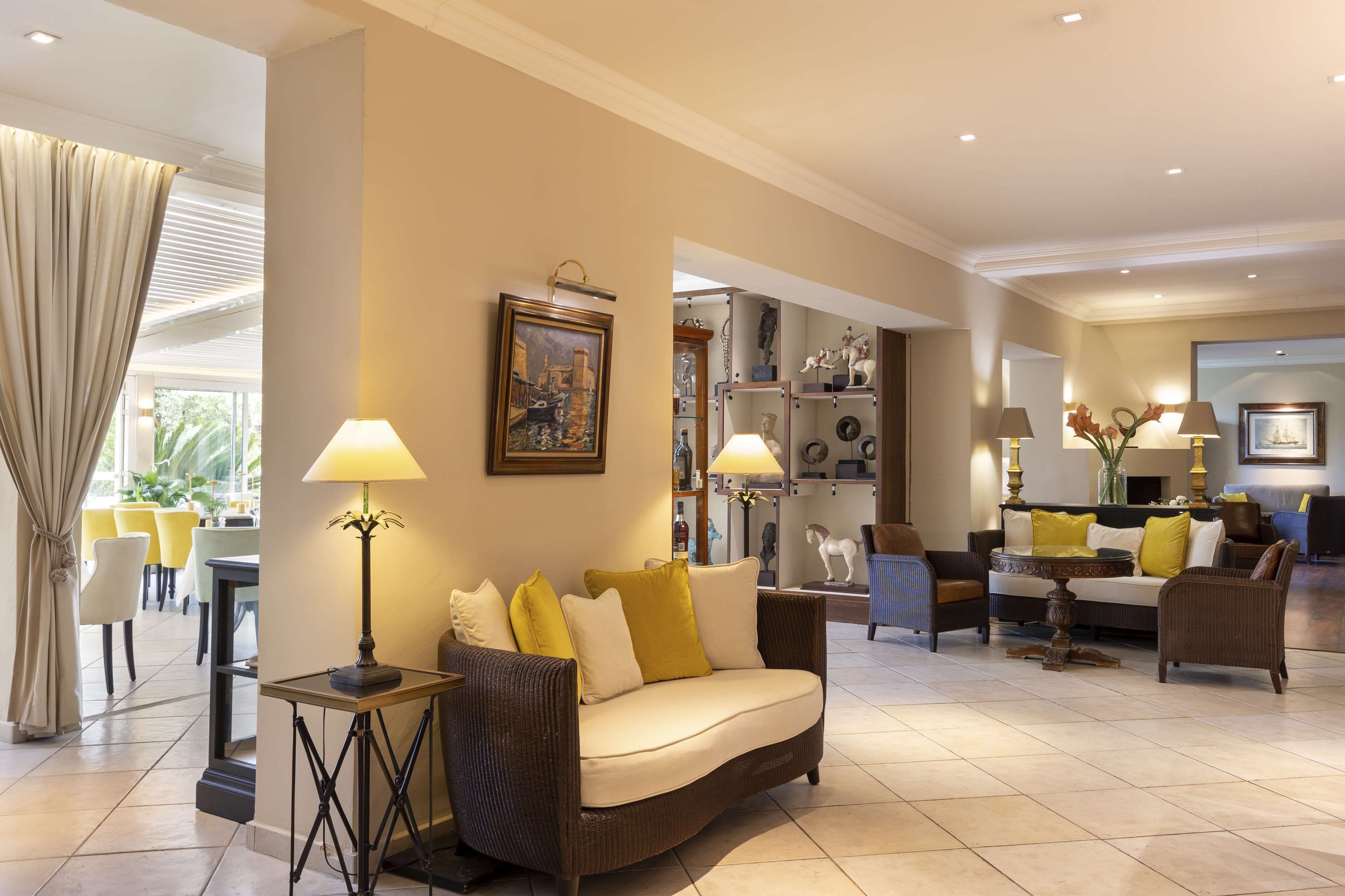 A spacious living area with a sofa, lamps, and a dining area in the background.