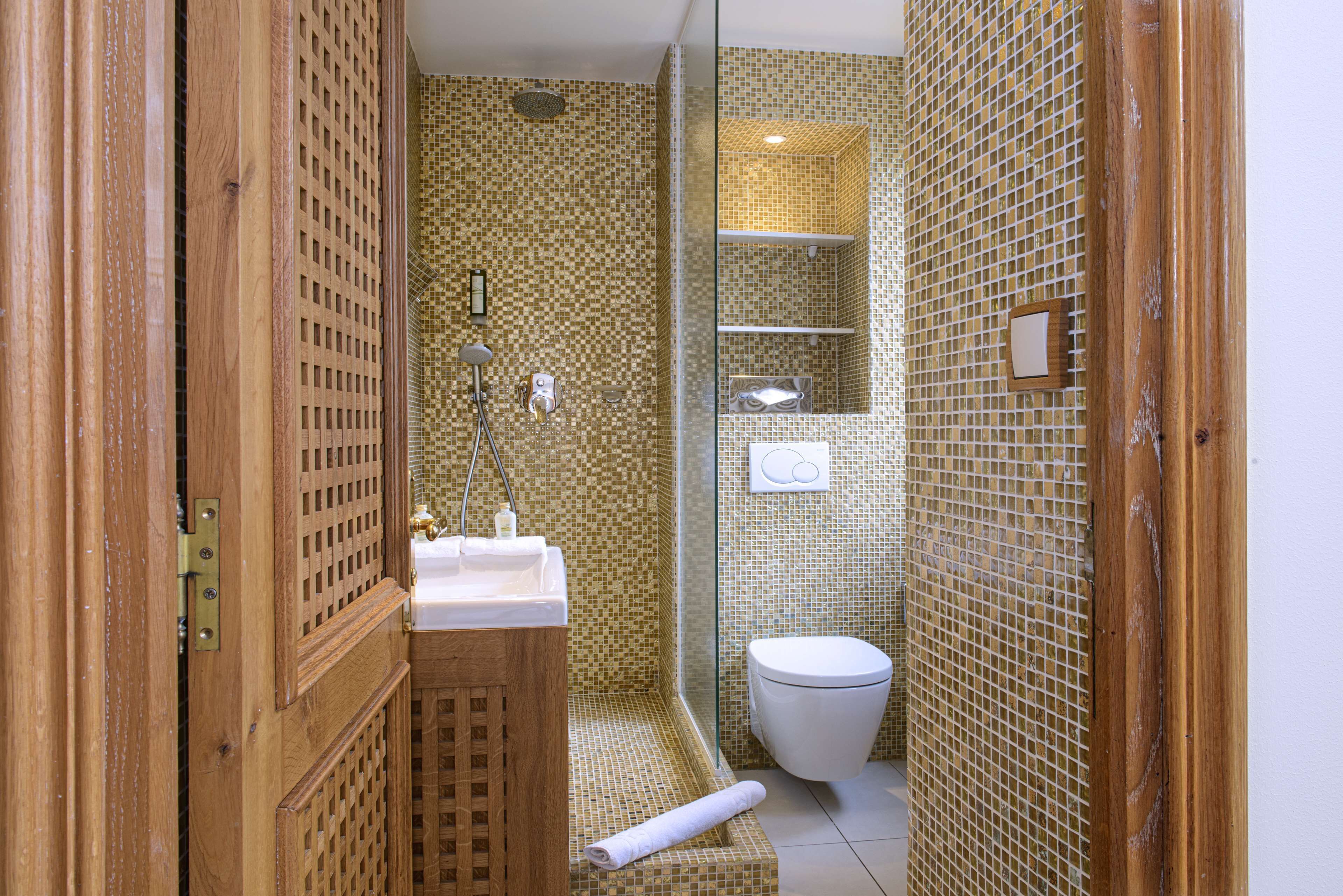 A bathroom with a shower, toilet, and sink.