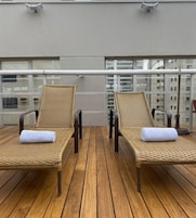 Una piscina al aire libre, sillones reclinables de piscina