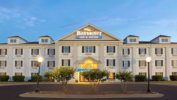A large, multi-story hotel with a prominent sign reading "Baymont Inn & Suites." - Baymont by Wyndham Pearl (Pearl)