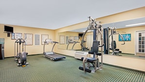 A gym with treadmills, elliptical machines, and weight stations. - Baymont by Wyndham Pearl (Pearl)