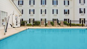A swimming pool with lounge chairs and a lifeguard stand. - Baymont by Wyndham Pearl (Pearl)