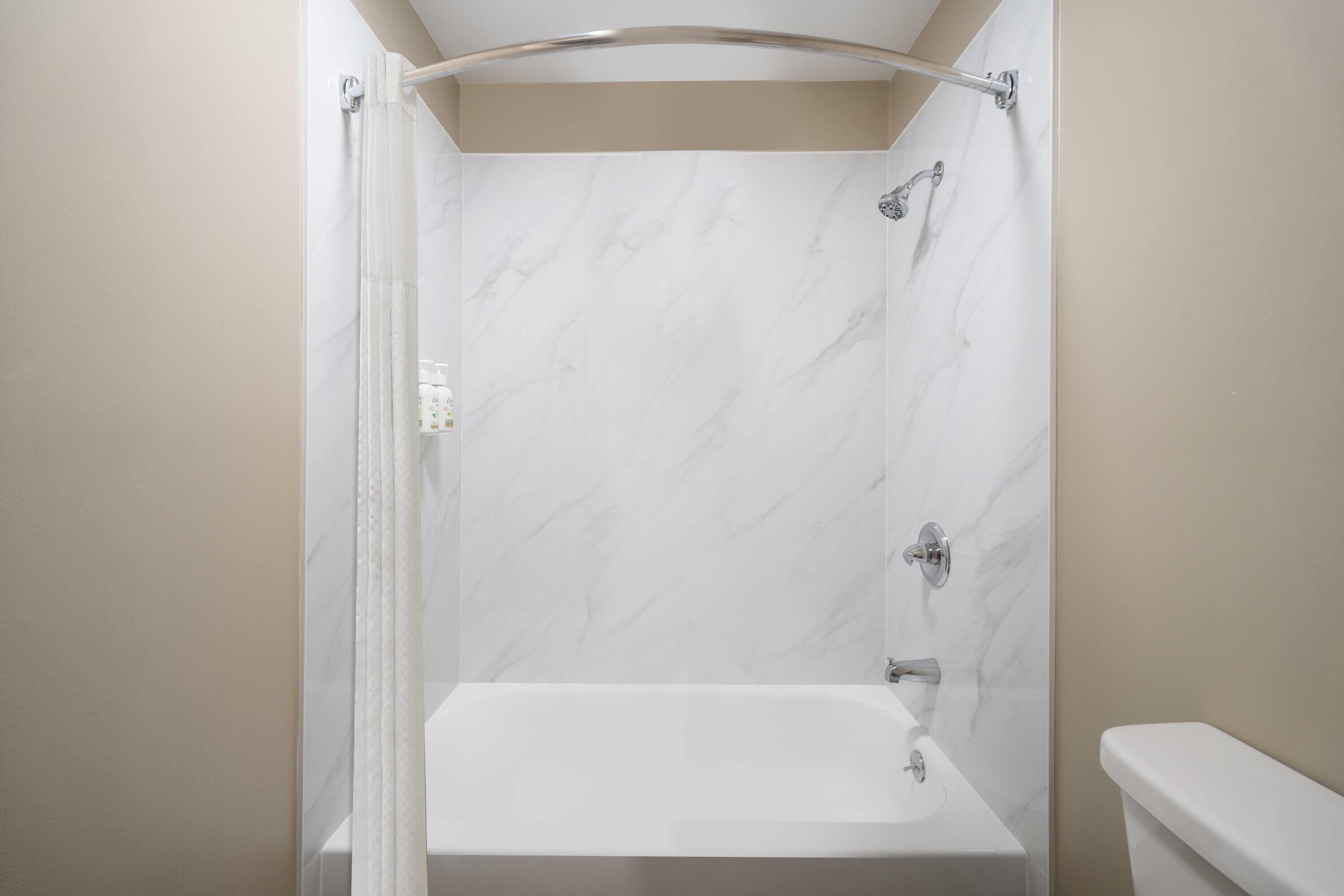 A bathroom with a shower, toilet, and sink.