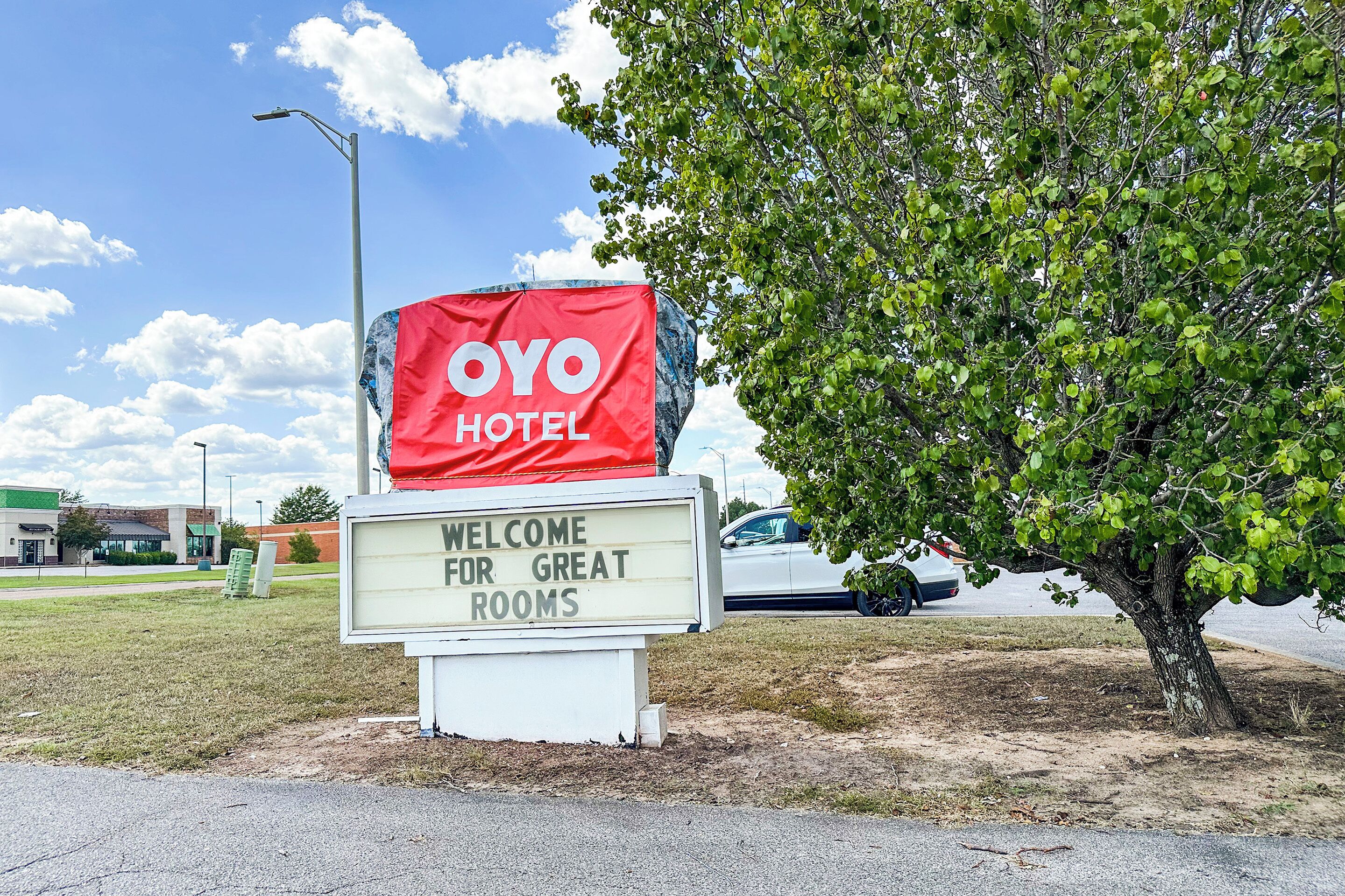 A hotel sign with "OYO HOTEL" and a welcome message for great rooms.