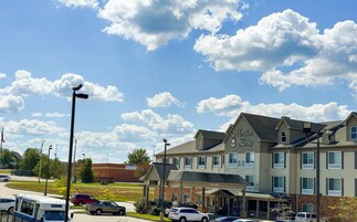 A multi-story hotel with a covered entrance and a sign reading "Meridian Living."