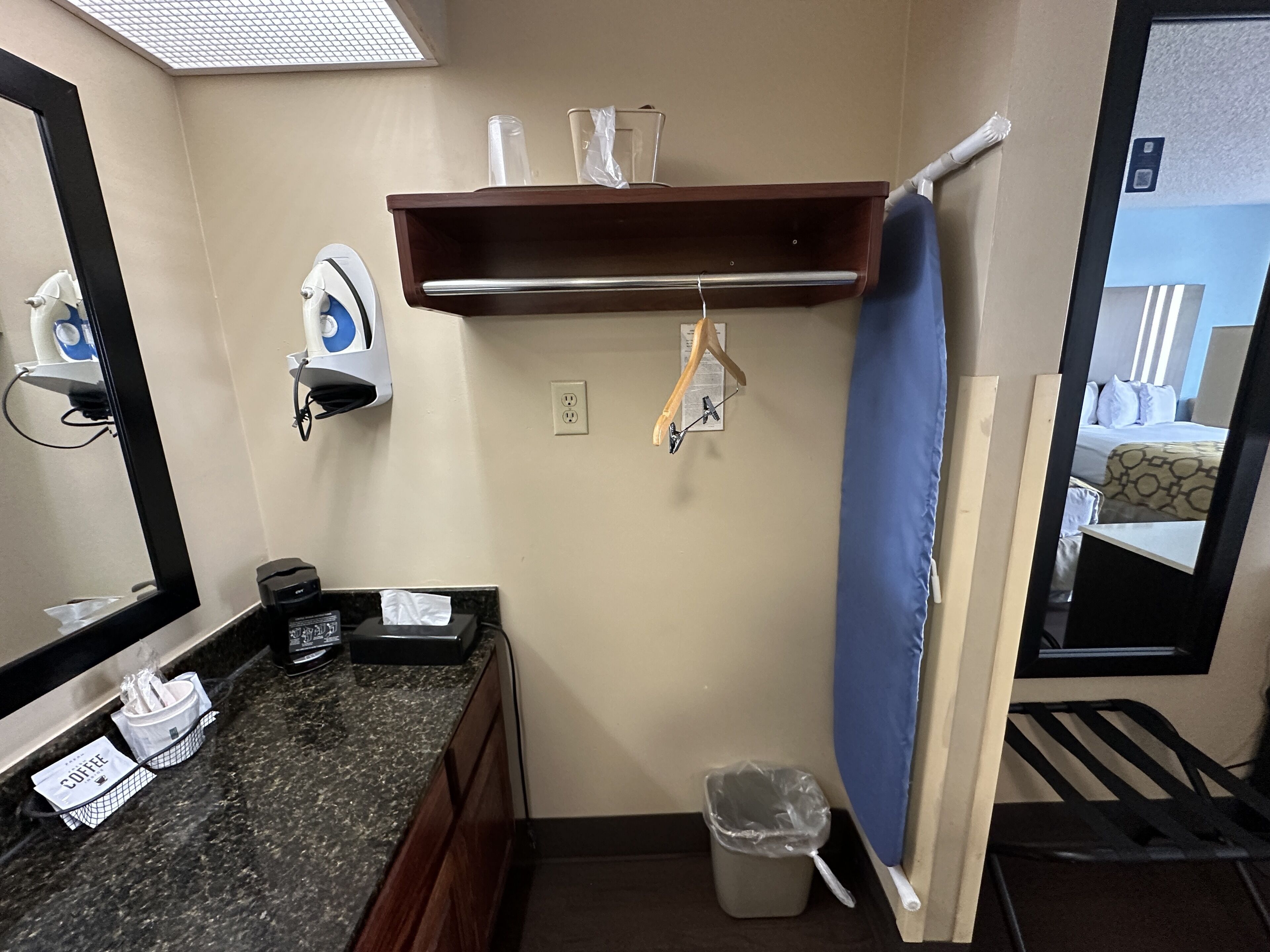 Un baño de hotel con lavamanos, espejo, toallero y cortina de ducha.
