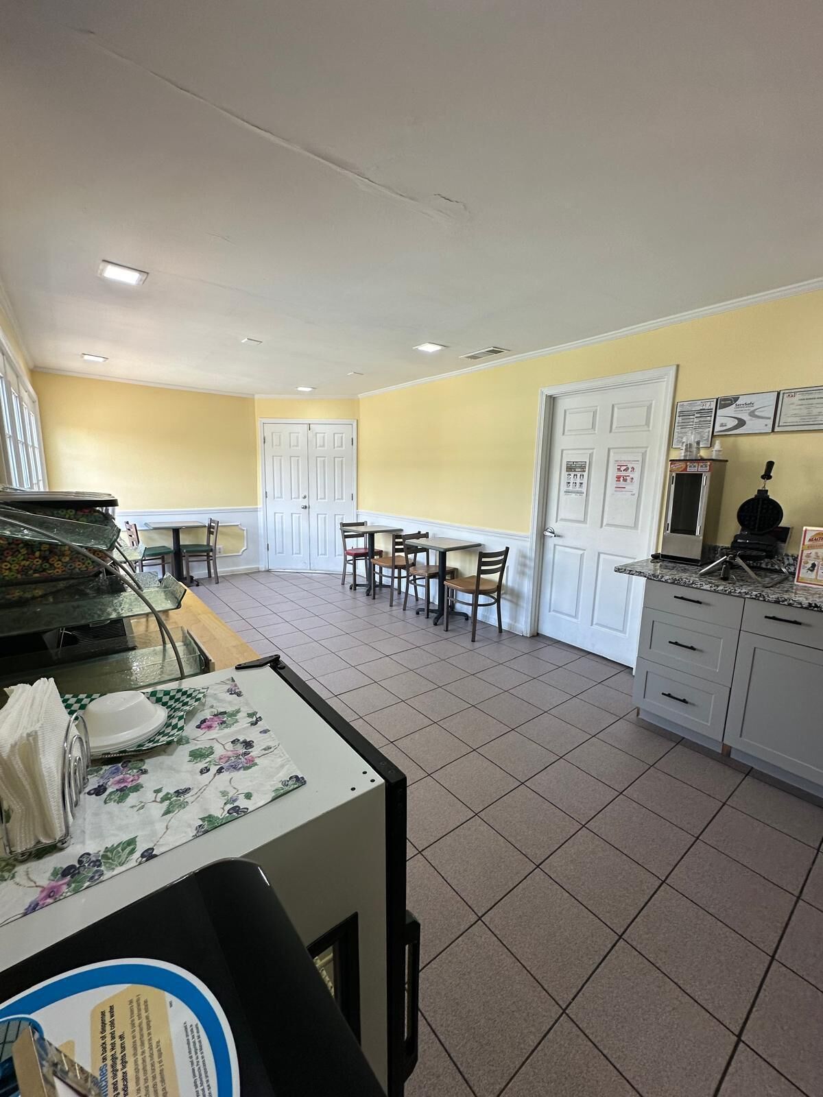 Comedor con barra libre, una mesa con sillas y zona de cocina con armarios y electrodomésticos.