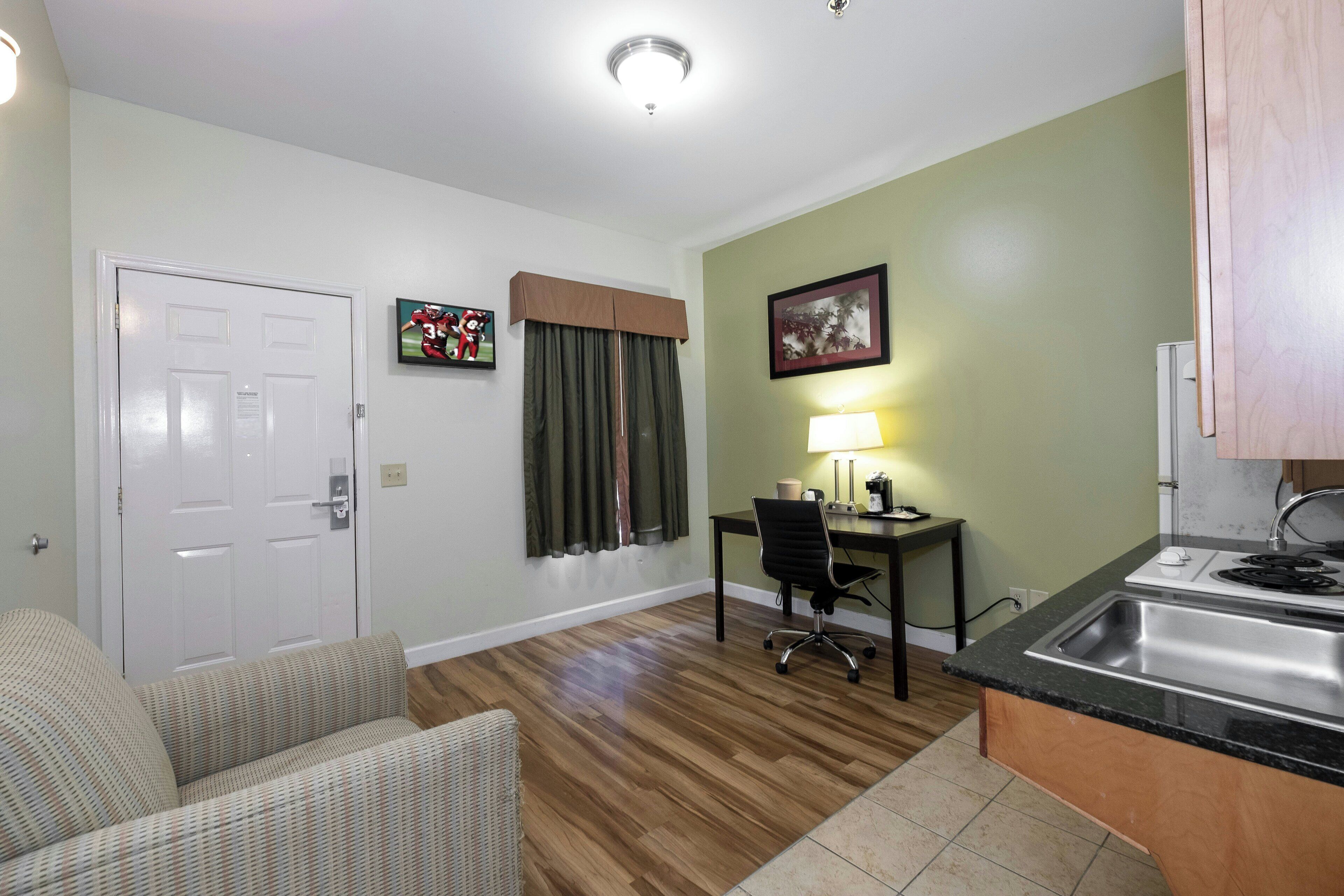 A compact living space with a kitchenette, a dining area, and a seating area.