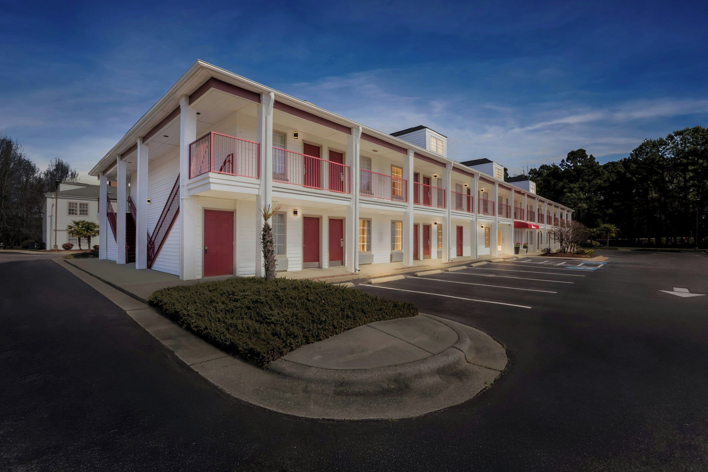Un motel de dos pisos, con múltiples balcones y un estacionamiento.