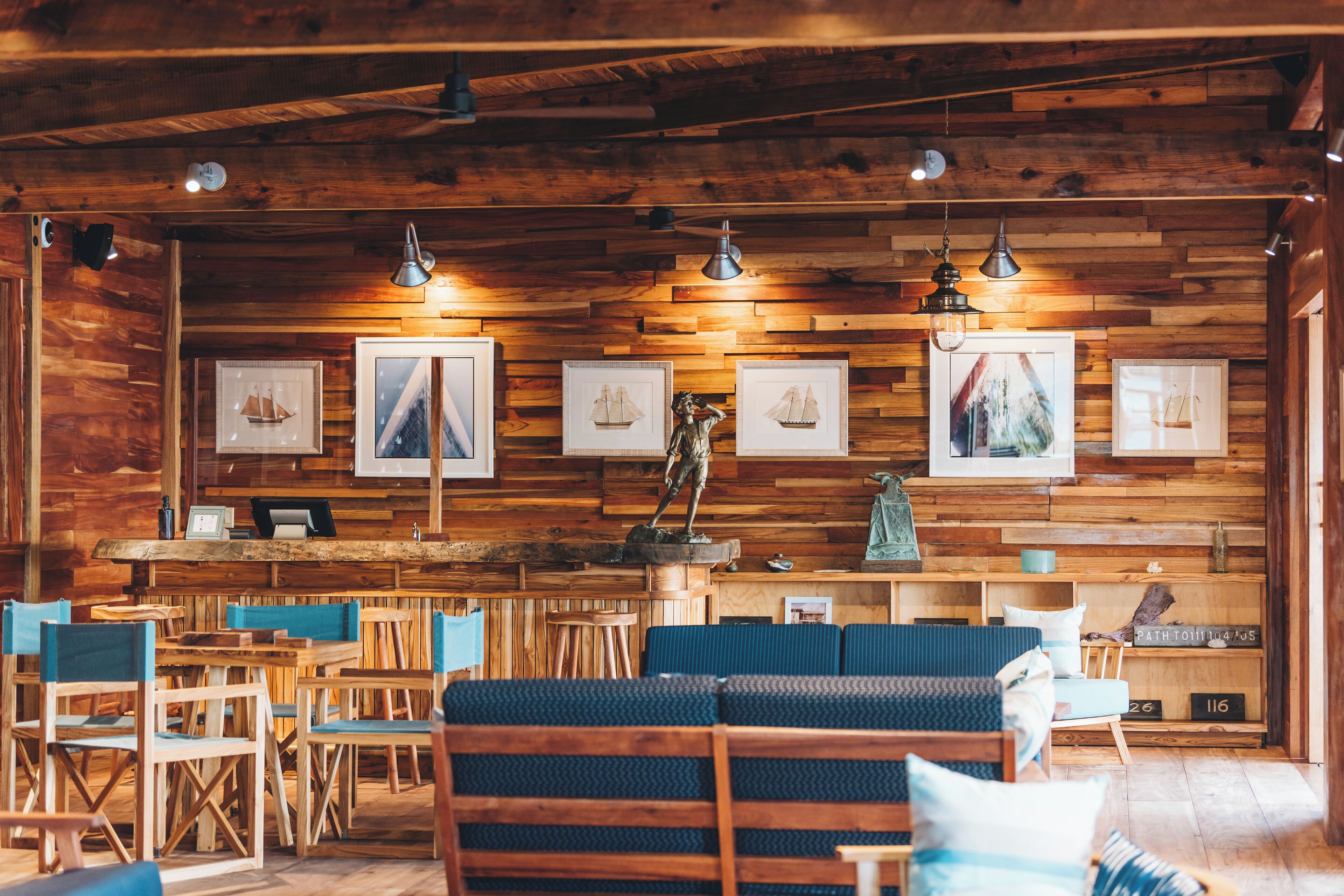 A wooden interior with a bar area, seating, and framed artwork on the walls.