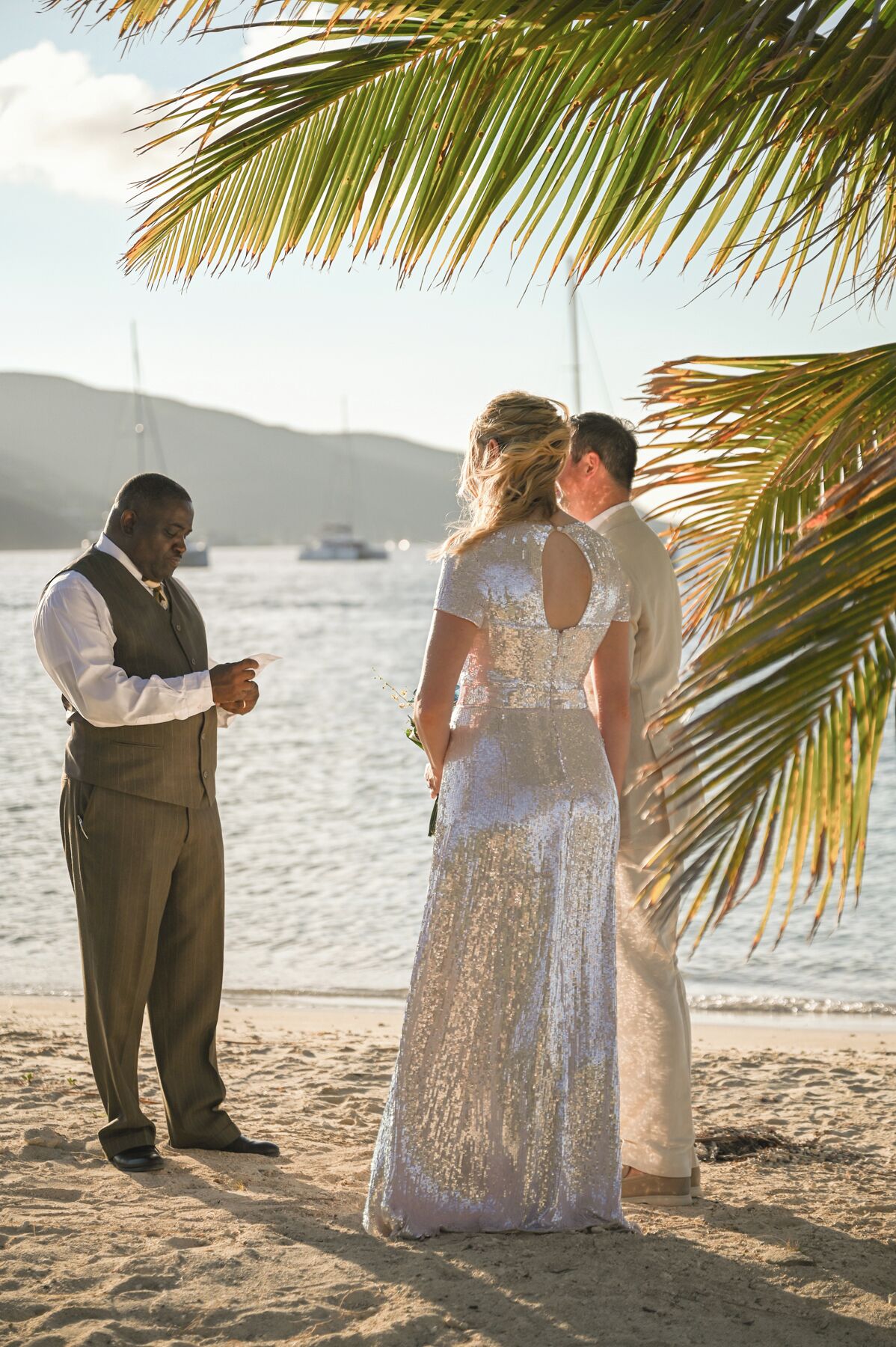 A beach wedding ceremony with a couple and a groom.