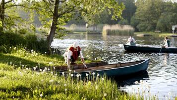 Roligt sølandskab med både og frodig vegetation.