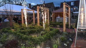 Un jardín con estructuras de madera y un jacuzzi.