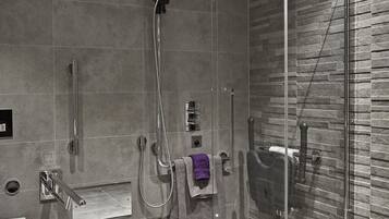 A modern bathroom with a glass-enclosed shower, a toilet, and a sink.