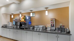 A hotel reception area with a self-service coffee station, a refrigerator, and a juice dispenser. - Best Western Northwest Inn (Dallas)