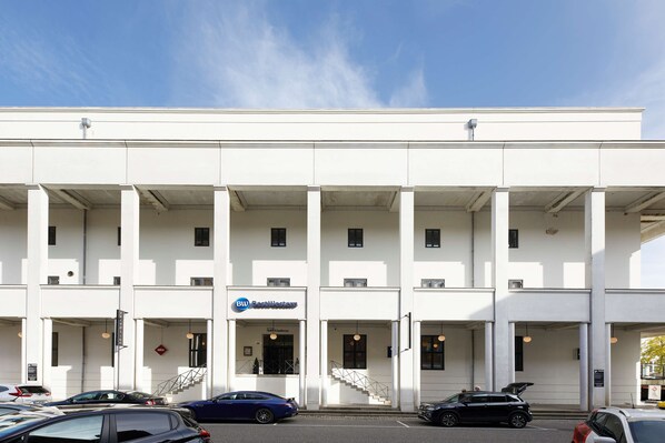 Un edificio moderno con fachada blanca, varias entradas y un cartel que dice 'BWI Business Center'.