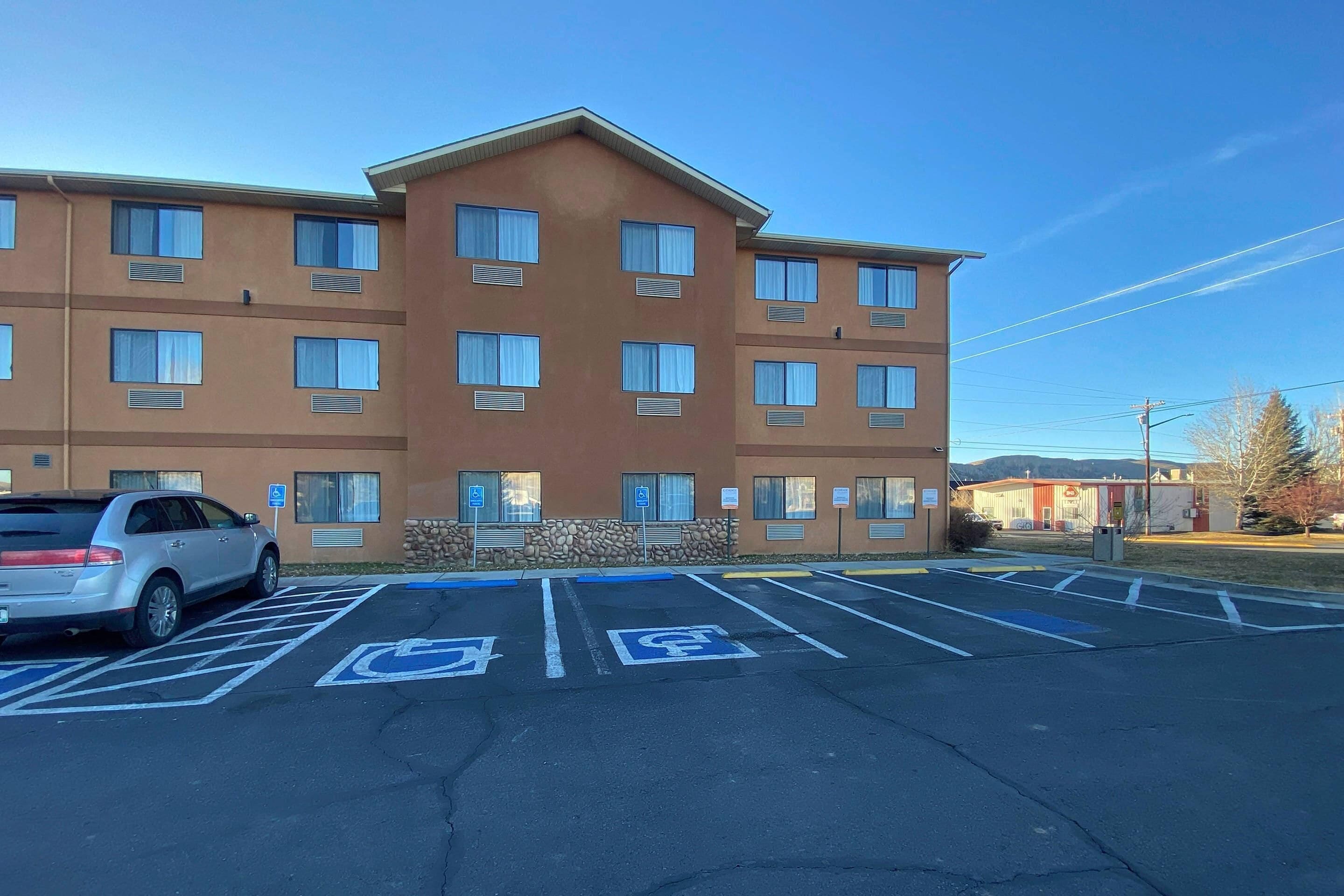 A multi-story hotel with parking spaces marked for disabled access.
