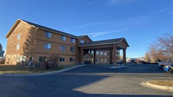 A multi-story hotel with a covered entrance and a parking lot.