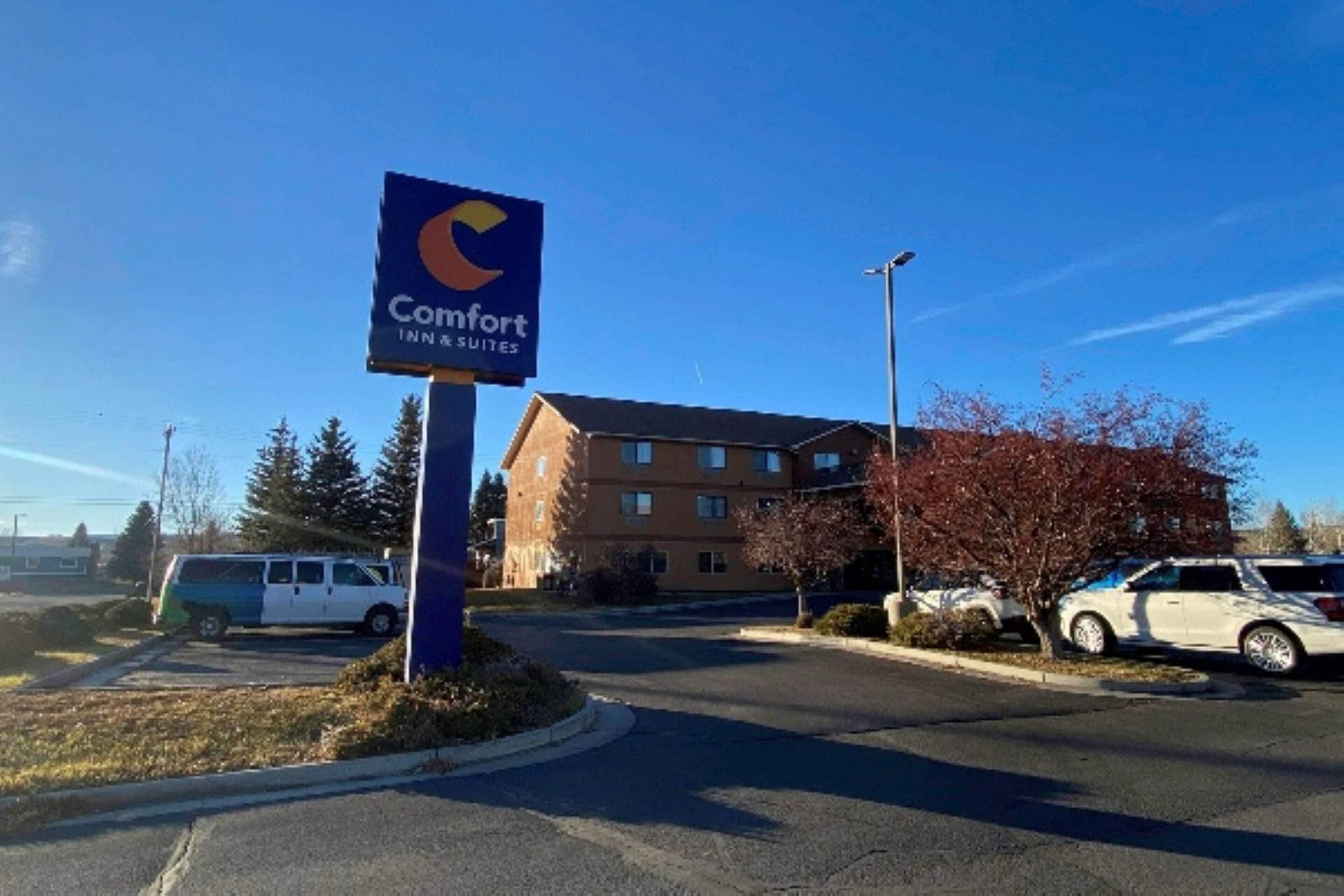 A Comfort Inn sign with a parking lot and a building in the background.