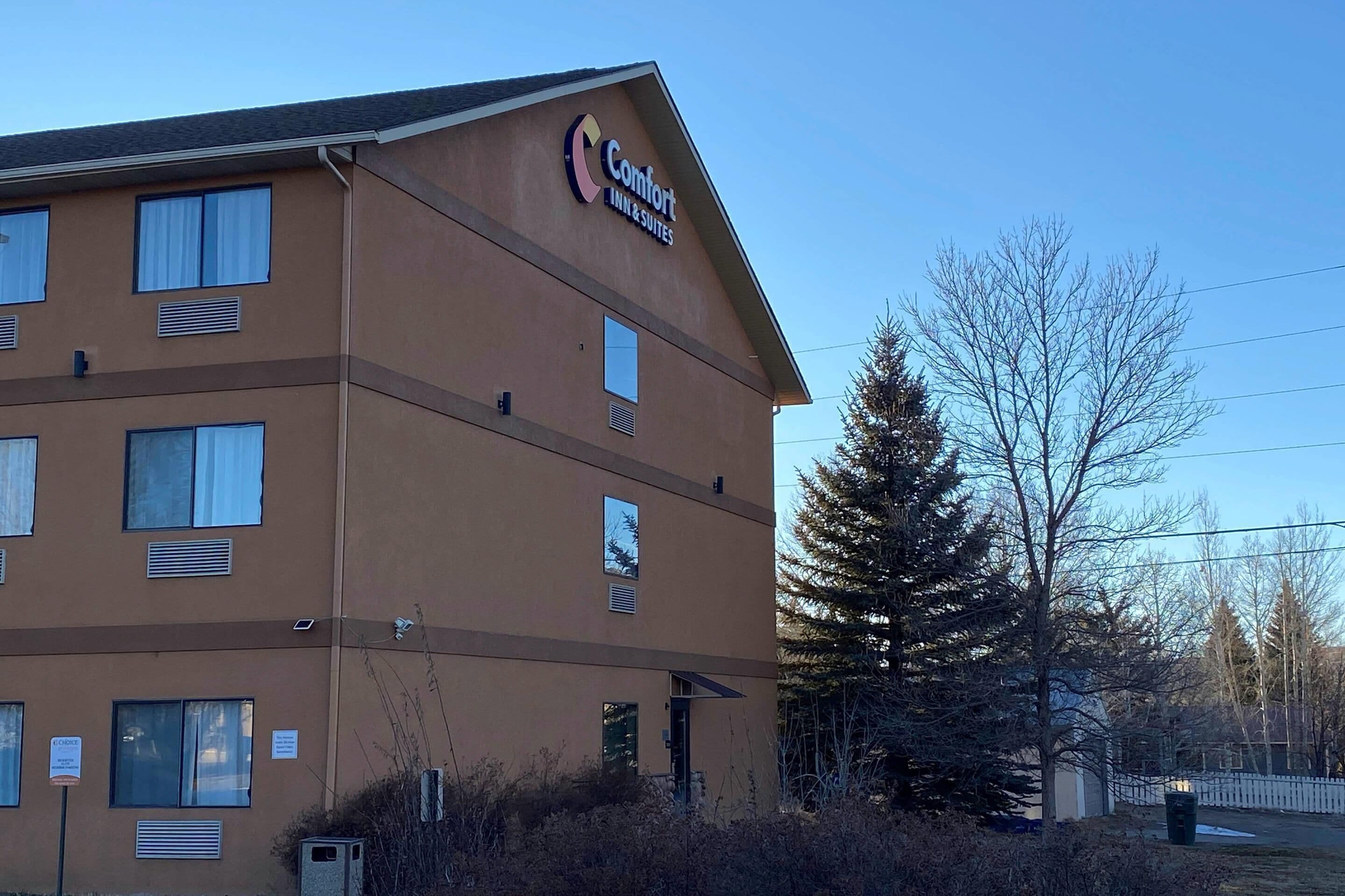 Un hotel de varios pisos con fachada marrón, ventanas grandes y un letrero que indica que es un Comfort Inn & Suites.