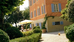 A building with a symmetrical facade, multiple windows with shutters, and a gravel pathway leading to the entrance. - Fontelunga Hotel & Villas (Foiano della Chiana)
