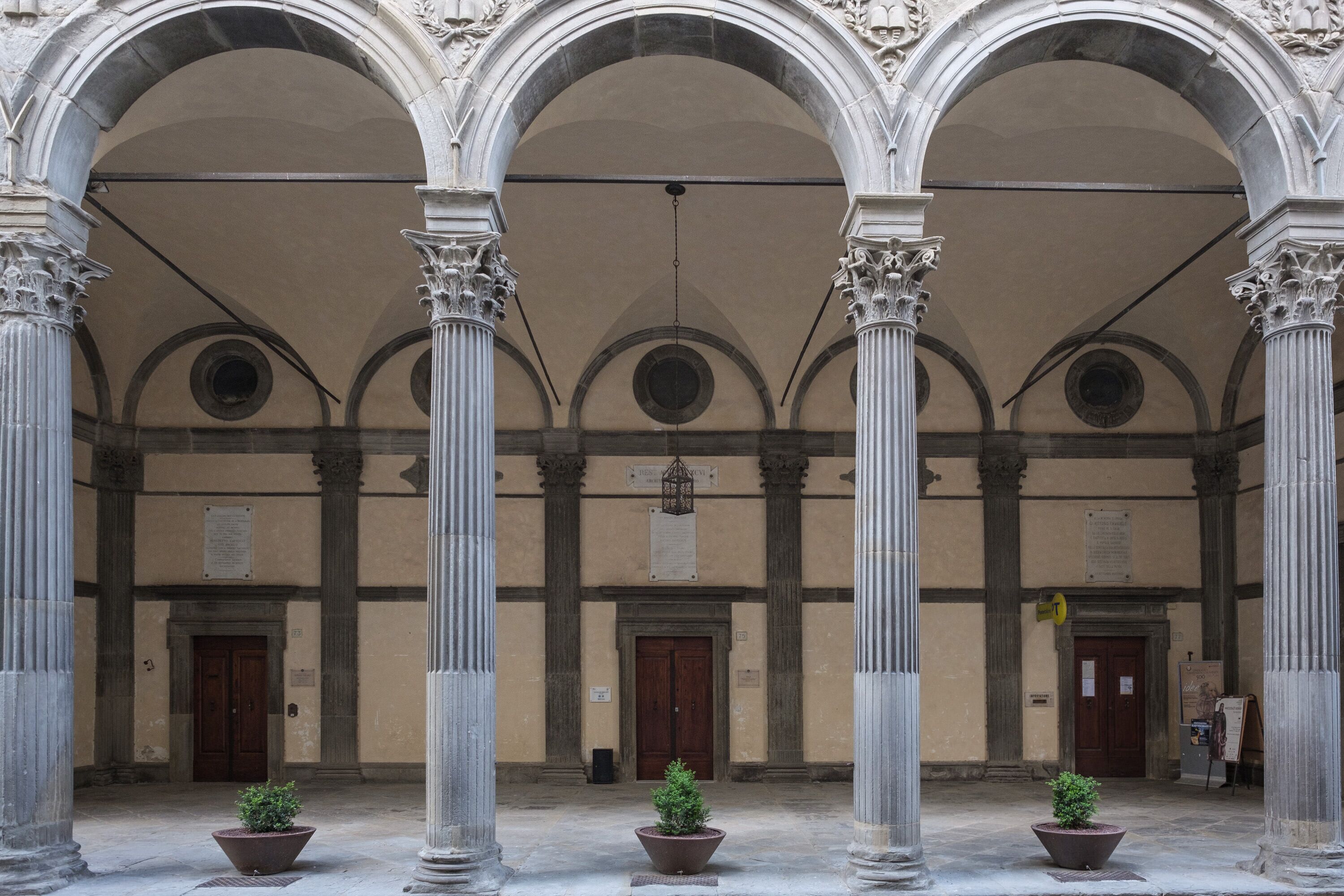 A classical building with three arches, columns, and a central door.