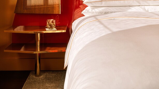 Une chambre d’hôtel avec un lit, une table de chevet et un meuble mural.