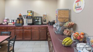 A breakfast area with a coffee machine, a cereal dispenser, and a fruit basket.