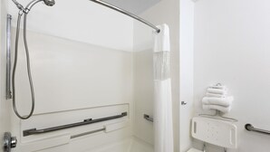 A bathroom with a shower, grab bars, a towel rack, and a toilet with a safety seat. - Super 8 by Wyndham Boone (Boone)