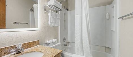 A bathroom with a sink, toilet, shower, and a towel rack.