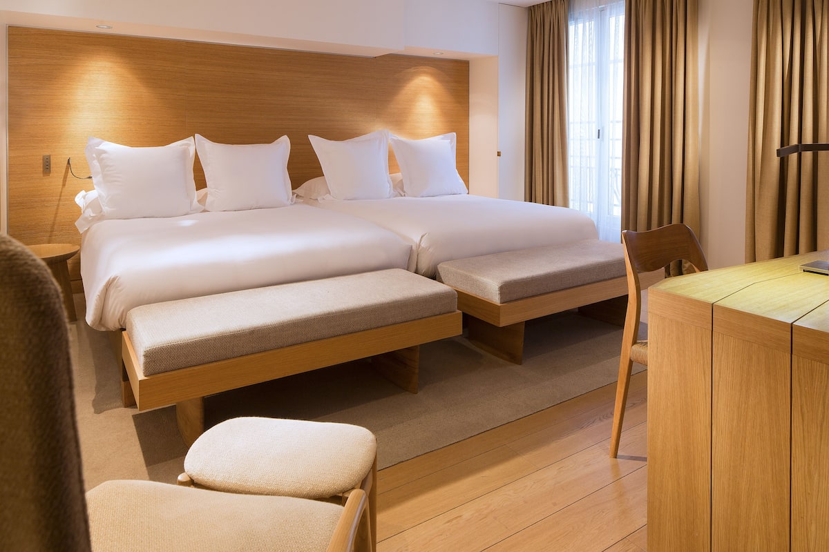 Una habitación de hotel con una cama grande, un escritorio y una silla.